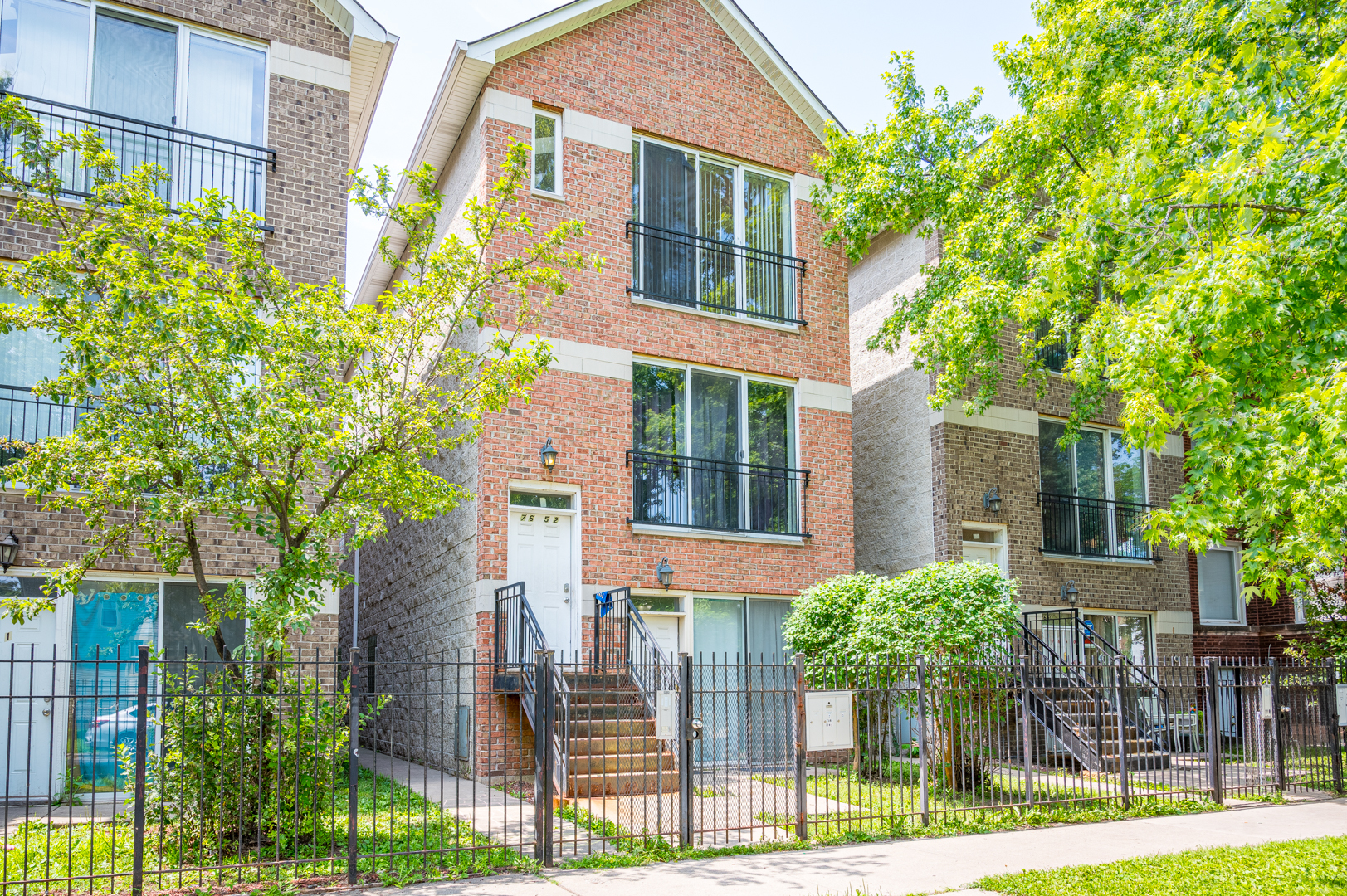 7652 South Colfax Avenue Chicago, IL 60649 - Photo 1 of 11 a view of a brick house with many windows next to a yard