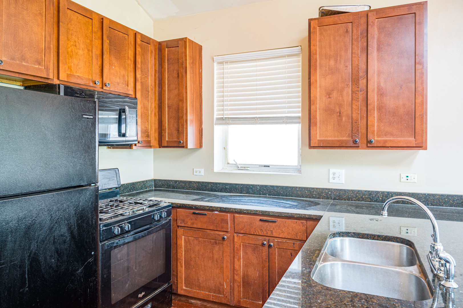 7652 South Colfax Avenue Chicago, IL 60649 - Photo 3 of 11 a kitchen with stainless steel appliances granite countertop a sink stove and cabinets