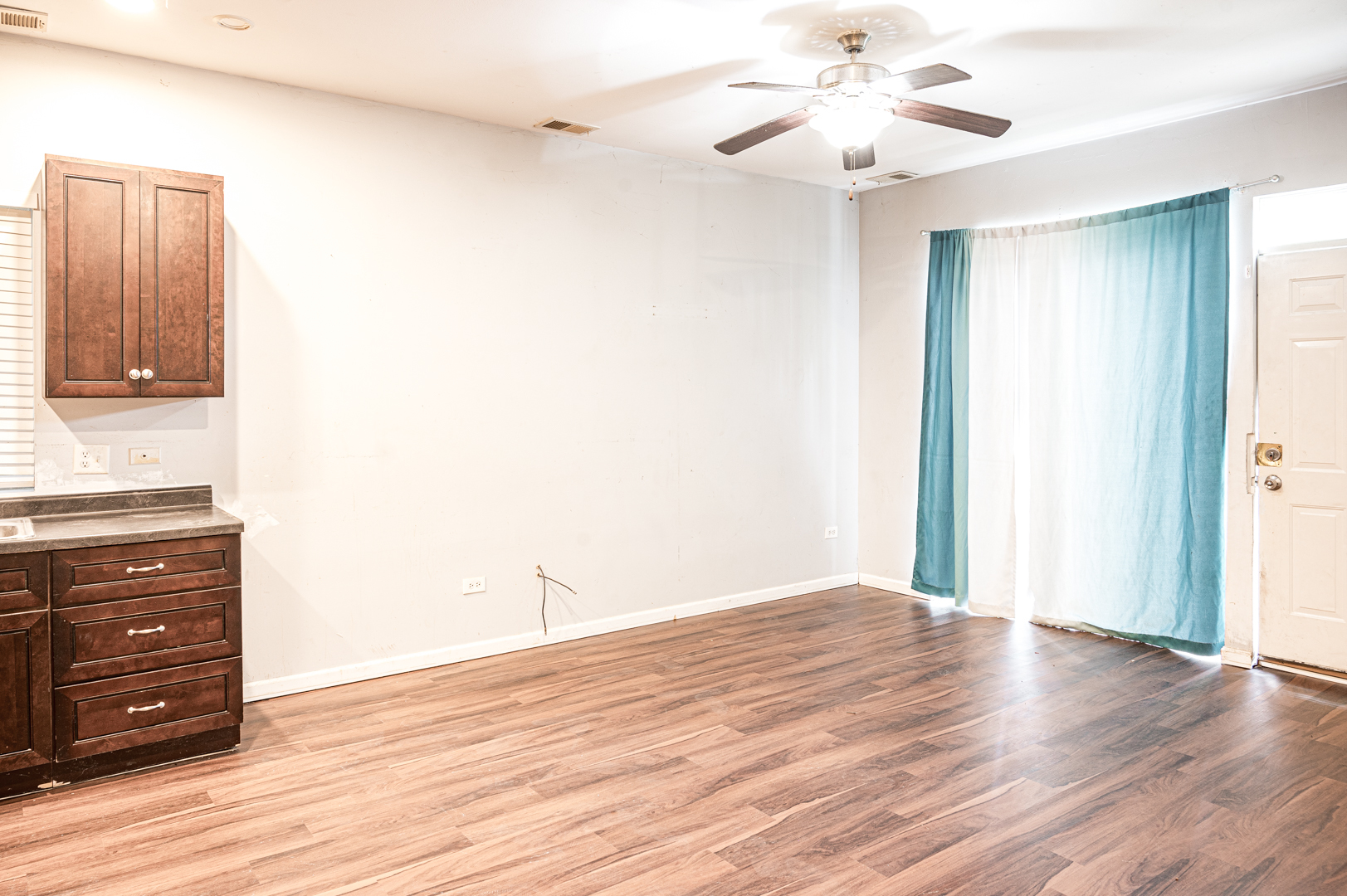 7652 South Colfax Avenue Chicago, IL 60649 - Photo 9 of 11 a view of a room with wooden floor and ceiling fan