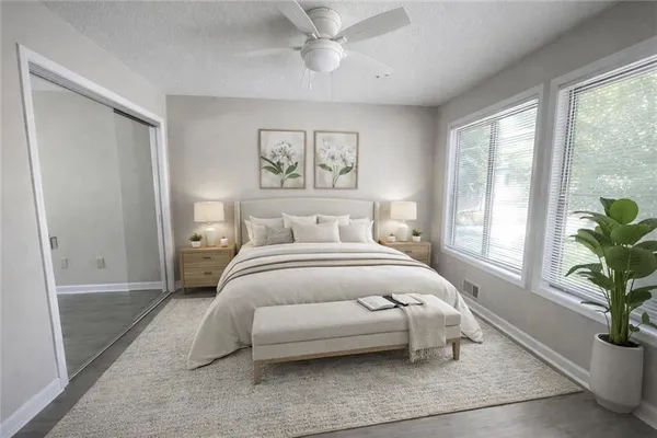 a bedroom with a large bed and a potted plant