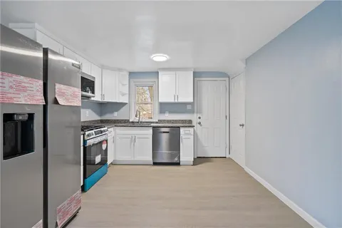 a kitchen with stainless steel appliances granite countertop a stove a sink and a refrigerator