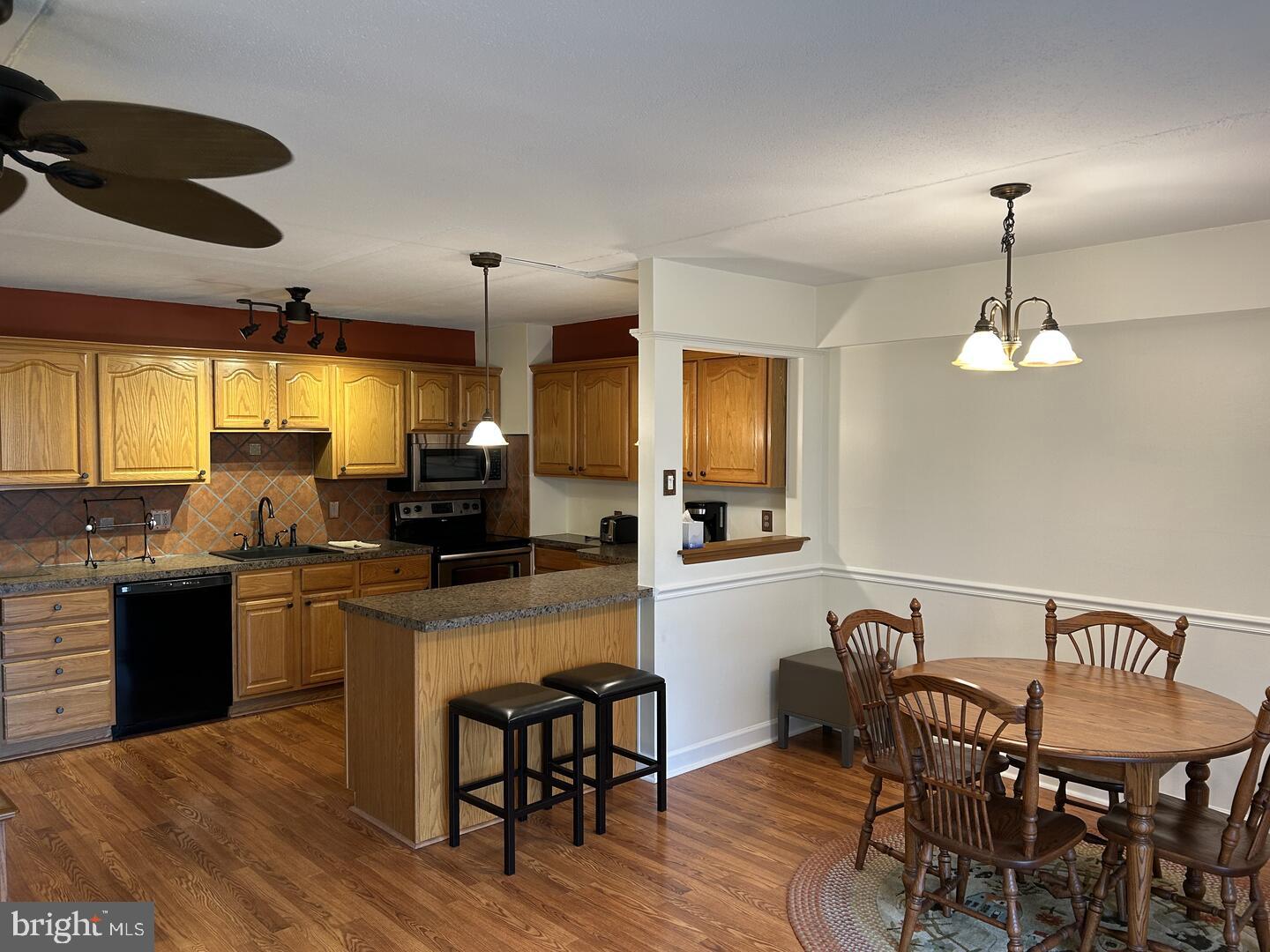 68 Welsh Tract Road, Unit D106 Newark, DE 19713 - Photo 3 of 10 a kitchen with stainless steel appliances kitchen island granite countertop a dining table chairs and a refrigerator