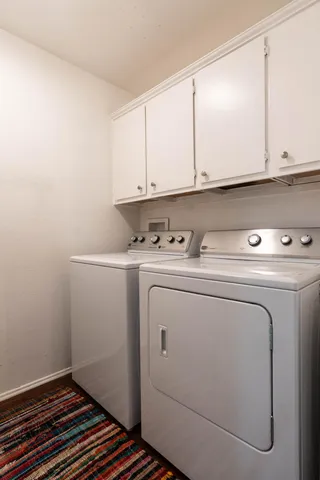 a view of an outdoor dining space with a table and chairs under an umbrella