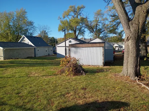 a view of a house with a large tree and a yard