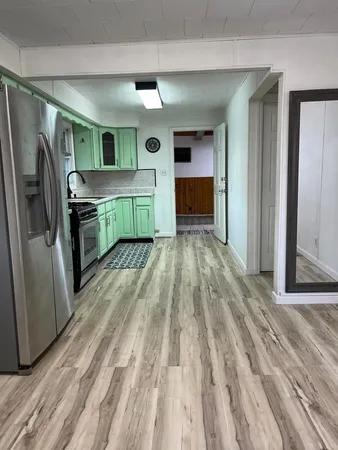 a kitchen with kitchen island wooden floors and stainless steel appliances