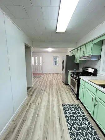 a kitchen with granite countertop a stove a sink and a refrigerator