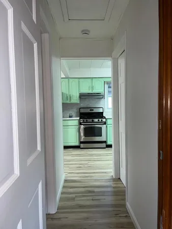 a kitchen with wooden floor electronic appliances and cabinets