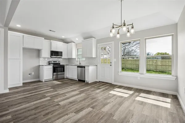 a view of kitchen with granite countertop cabinets and refrigerator