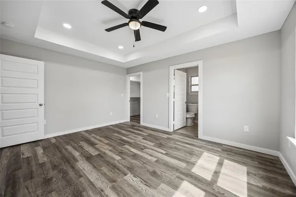 an empty room with closet and a ceiling fan