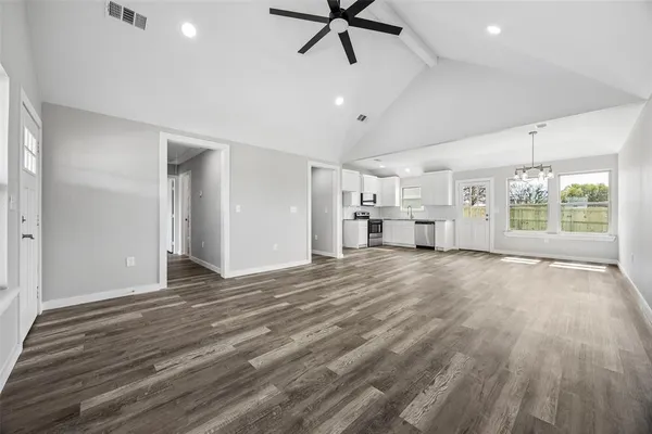 a view of empty room with wooden floor and window