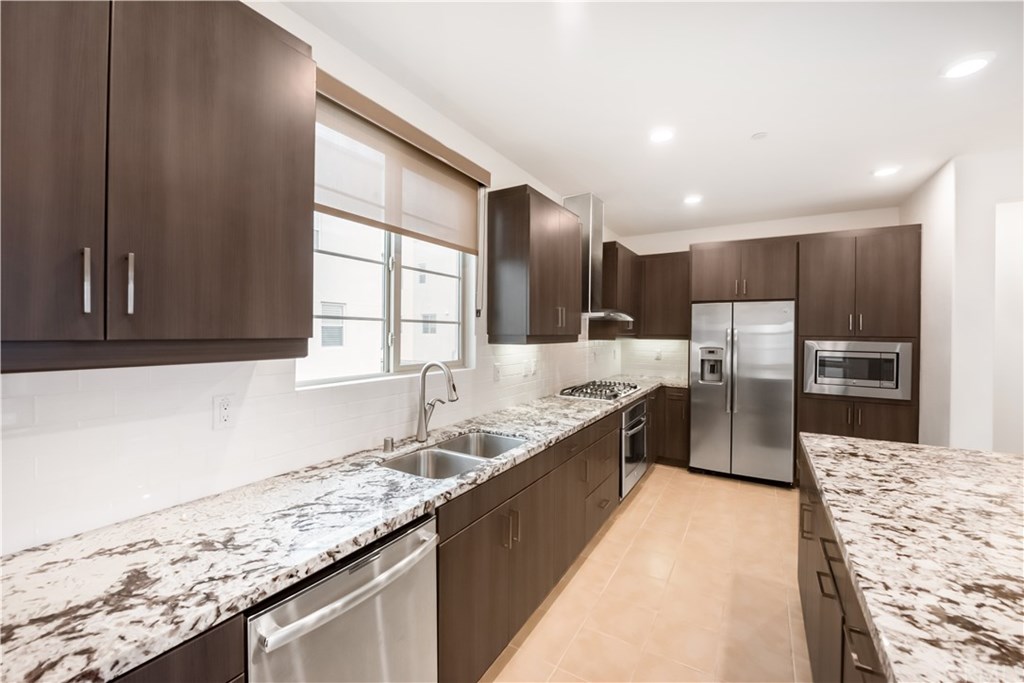 a large kitchen with granite countertop a sink and a stove