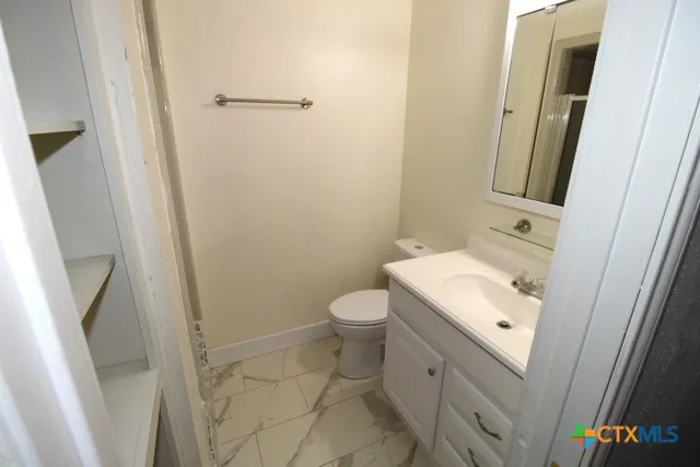 a bathroom with a sink a toilet and a mirror