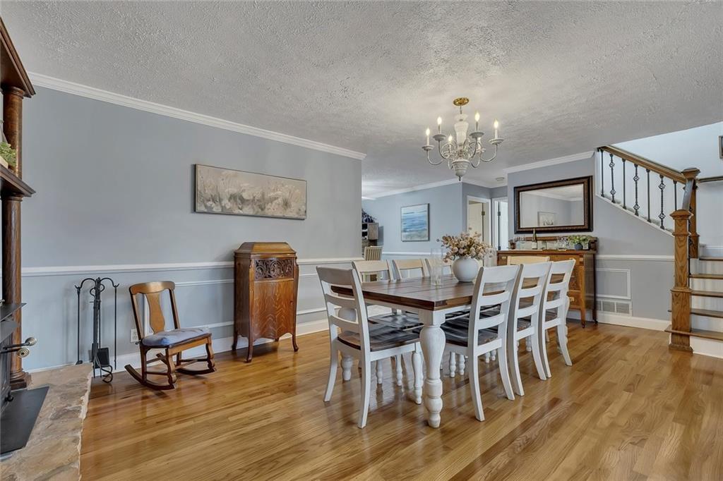 399 Smith Road Ball Ground, GA 30107 - Photo 16 of 63 a view of a dining room with furniture and wooden floor
