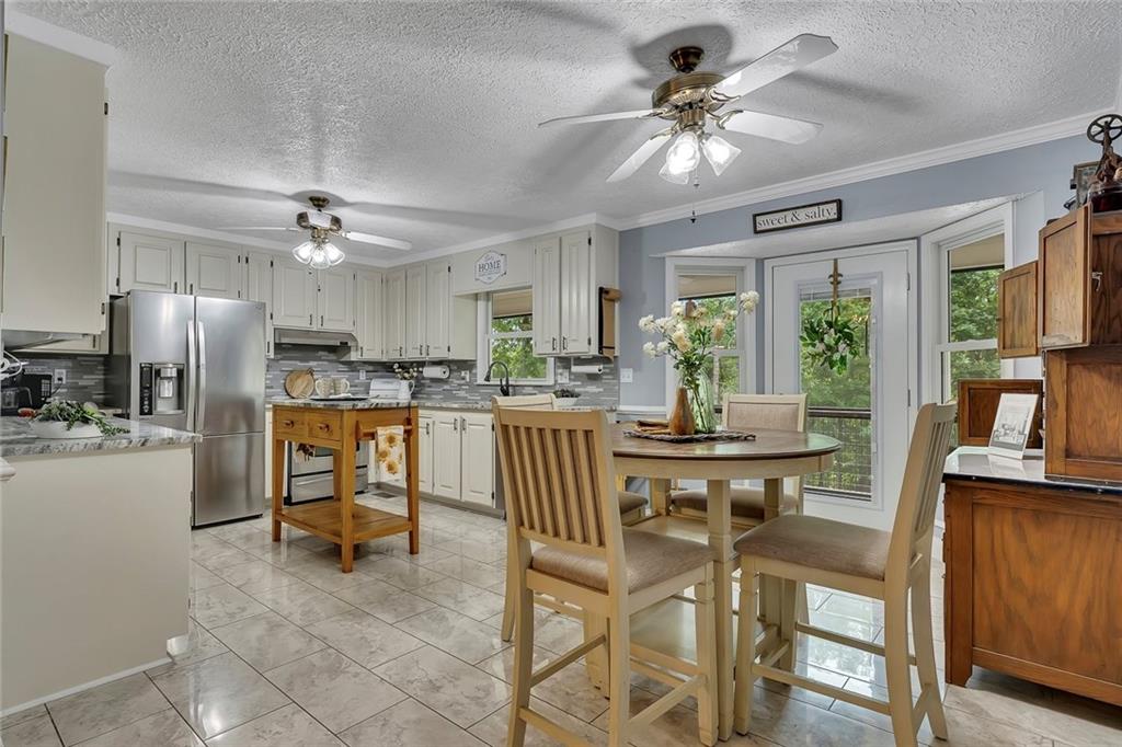 399 Smith Road Ball Ground, GA 30107 - Photo 17 of 63 a kitchen with stainless steel appliances a table chairs refrigerator and cabinets