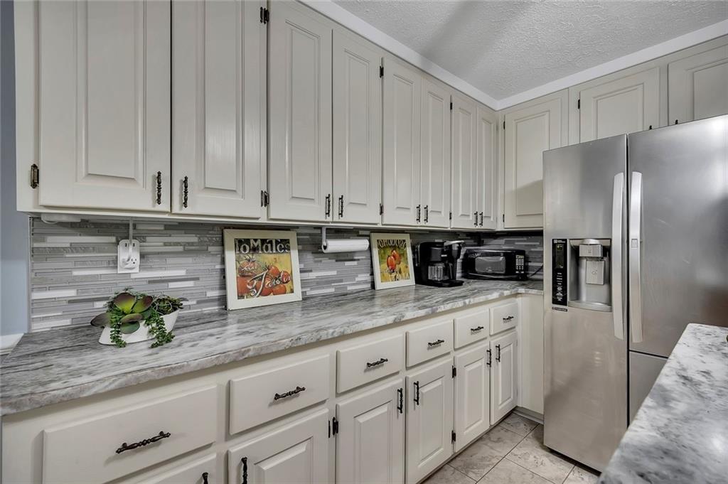 399 Smith Road Ball Ground, GA 30107 - Photo 22 of 63 a kitchen with stainless steel appliances granite countertop a sink a stove and refrigerator
