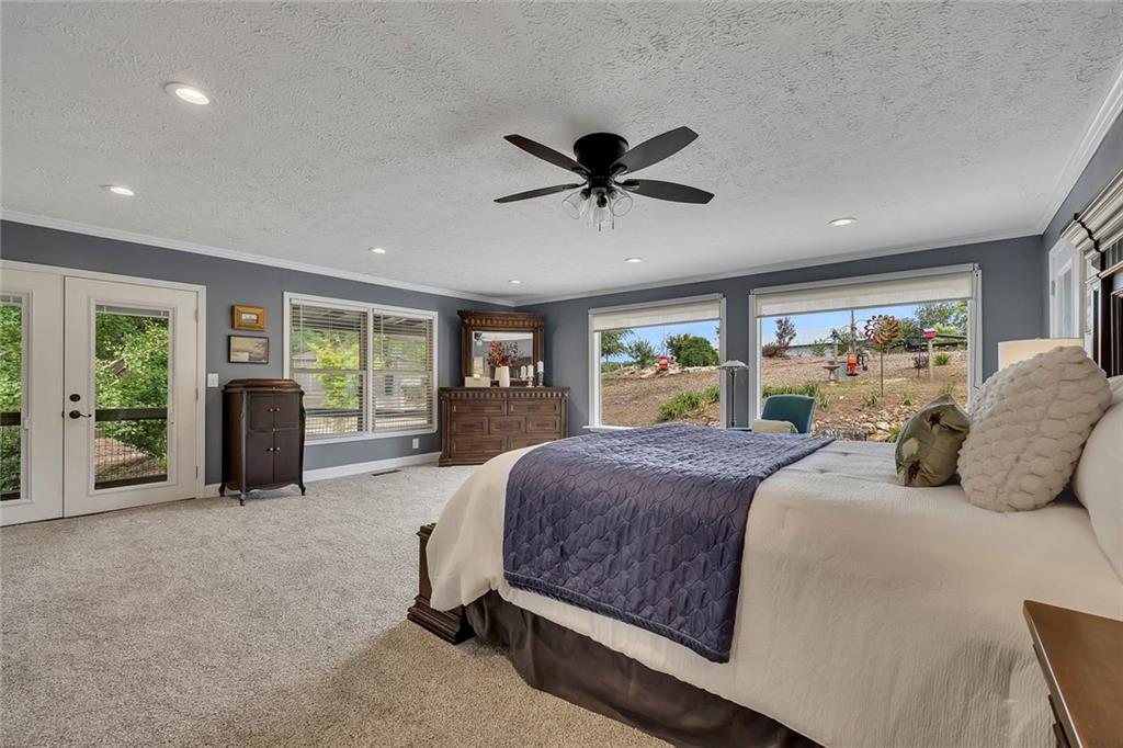 399 Smith Road Ball Ground, GA 30107 - Photo 24 of 63 a spacious bedroom with a large bed and a large window