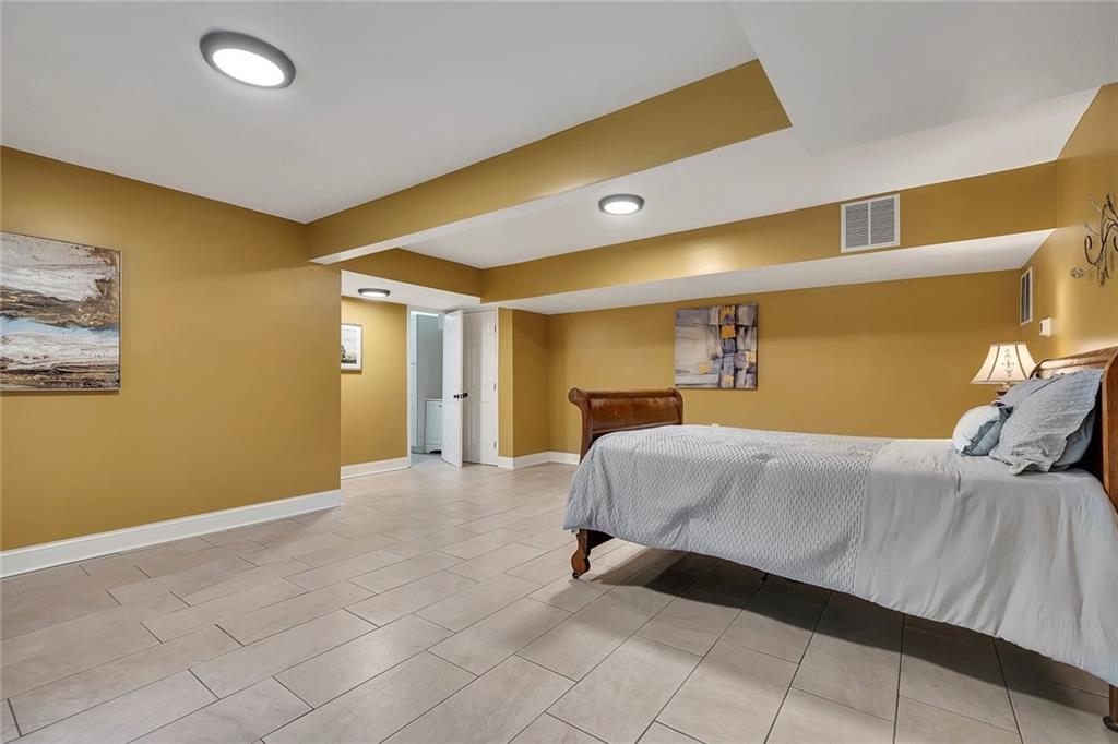 399 Smith Road Ball Ground, GA 30107 - Photo 36 of 63 a bedroom with a bed and a painting on the wall