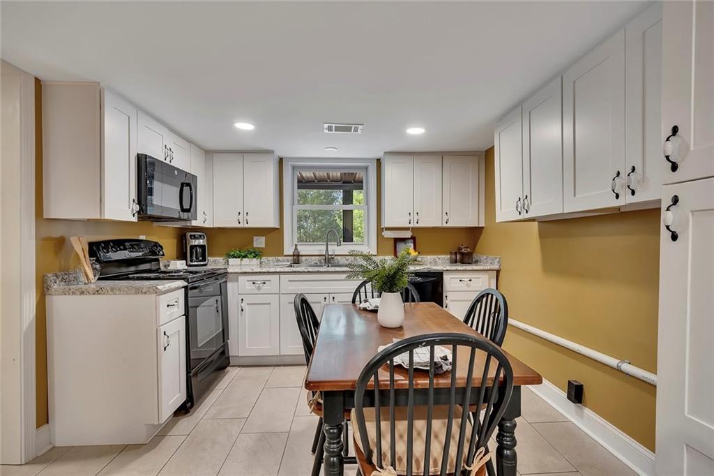 399 Smith Road Ball Ground, GA 30107 - Photo 41 of 63 a kitchen with sink a refrigerator and wooden cabinets