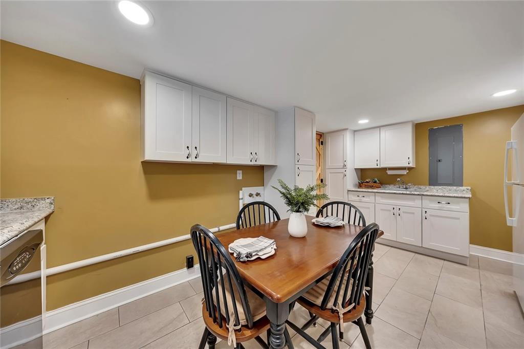 399 Smith Road Ball Ground, GA 30107 - Photo 42 of 63 a kitchen with a dining table chairs and a refrigerator