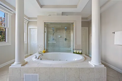 a bathroom with a granite countertop sink a mirror and a bathtub