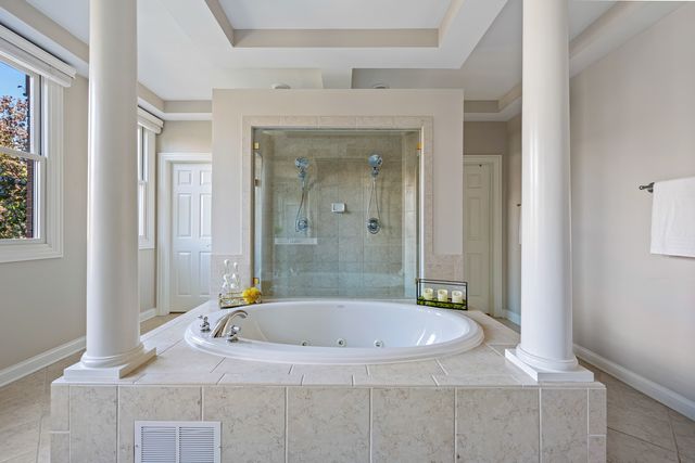 a bathroom with a granite countertop sink a mirror and a bathtub