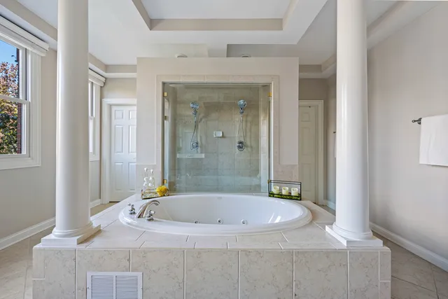 a bathroom with a granite countertop sink a mirror and a bathtub