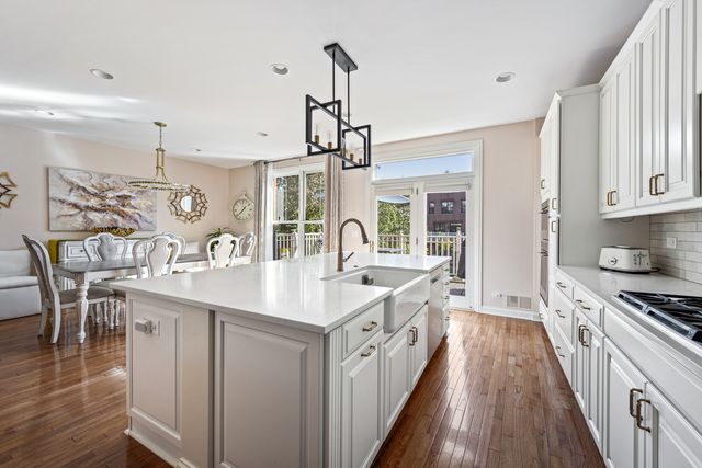 a kitchen with sink stove and wooden floor