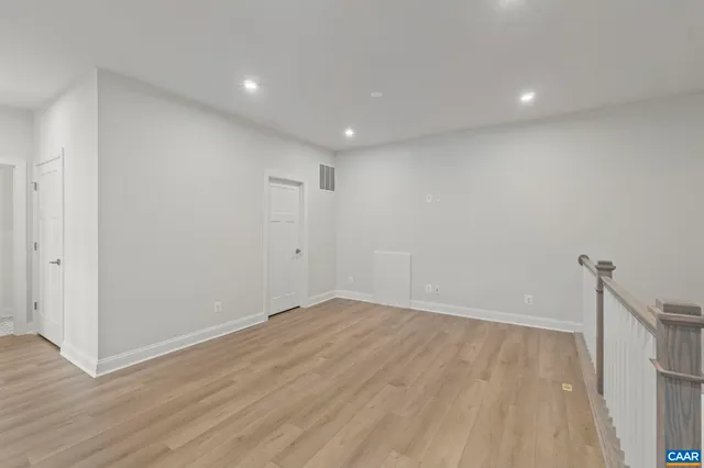 a view of empty room with wooden floor