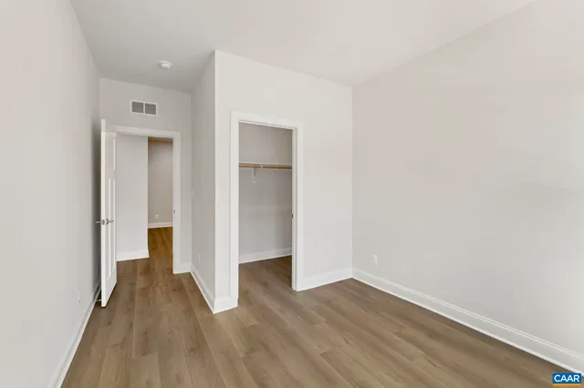 a view of a room with wooden floor and a hallway