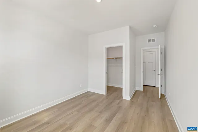 a view of an empty room with wooden floor