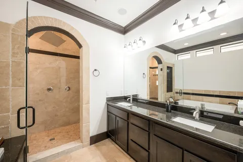 a bathroom with a double vanity sink mirror and shower