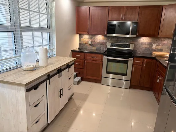 a kitchen with stainless steel appliances wooden cabinets and a sink