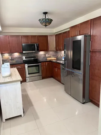 a kitchen with stainless steel appliances granite countertop a refrigerator and a stove