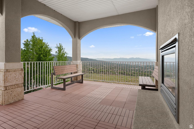 708 Eagle Rdg Drive Bountiful, UT 84010 - Photo 17 of 69 Covered balcony featuring arched entryways, a built-in outdoor fireplace, and modular flooring