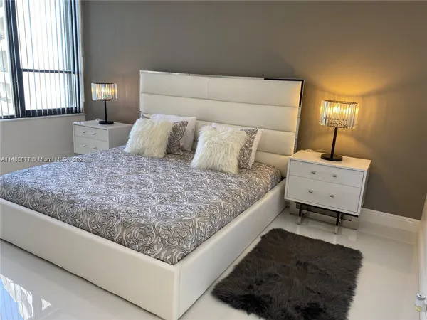 a bed sitting in a bedroom next to a window