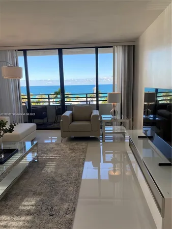 a living room with furniture and large windows