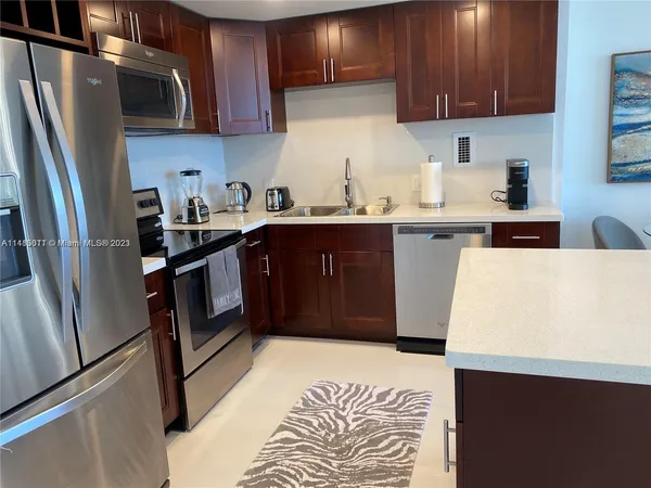 a kitchen with stainless steel appliances granite countertop a refrigerator stove a sink and dishwasher