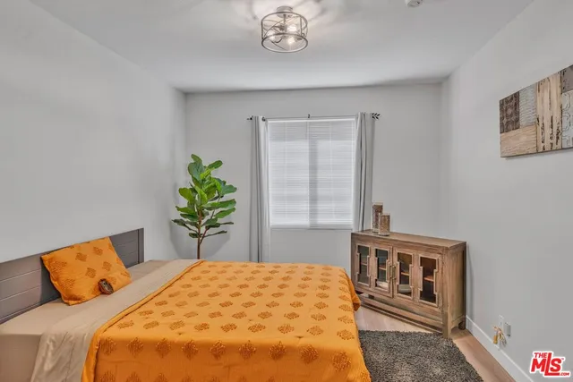 a bedroom with a bed and a potted plant