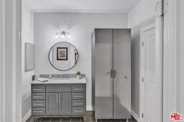 a bathroom with a sink vanity mirror and a shower