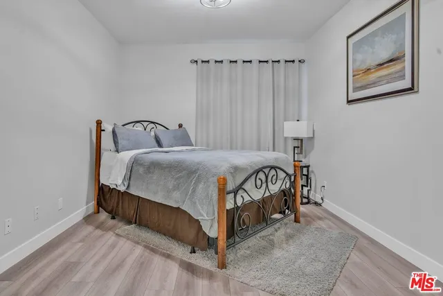 a bedroom with a bed and a painting on the wall