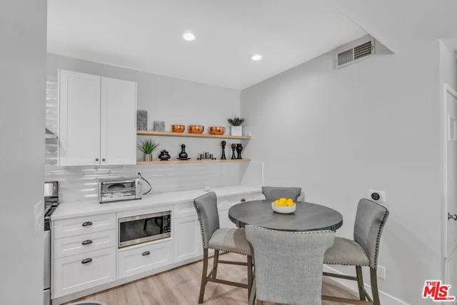 a kitchen with appliances cabinets and chair