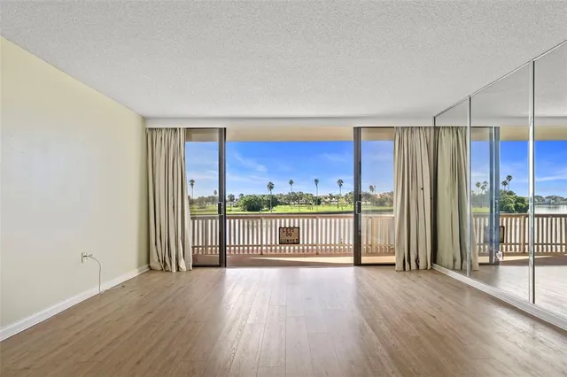 a view of a living room hardwood floor and a large window