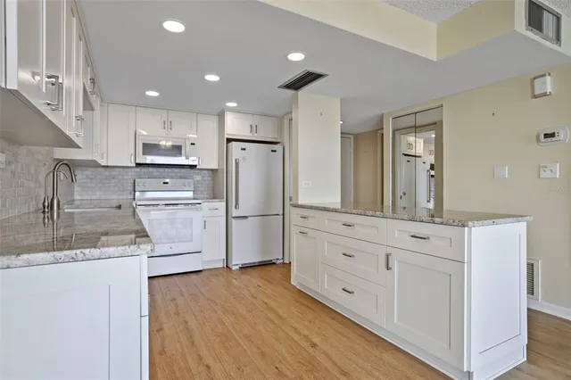 a kitchen with white cabinets and stainless steel appliances