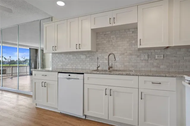 a kitchen with stainless steel appliances granite countertop a sink and cabinets