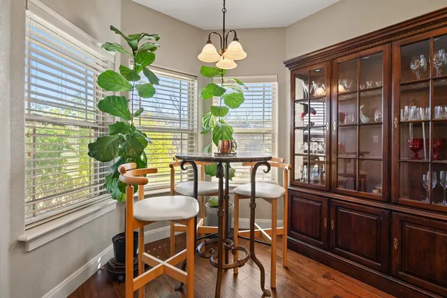 a dining room filled chandelier and wooden floor