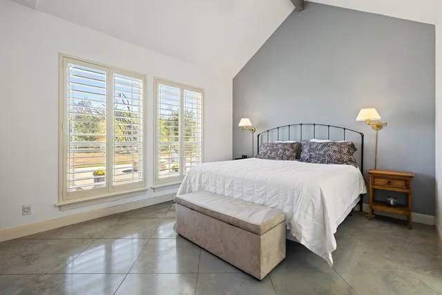 a bed sitting in a bedroom next to a window