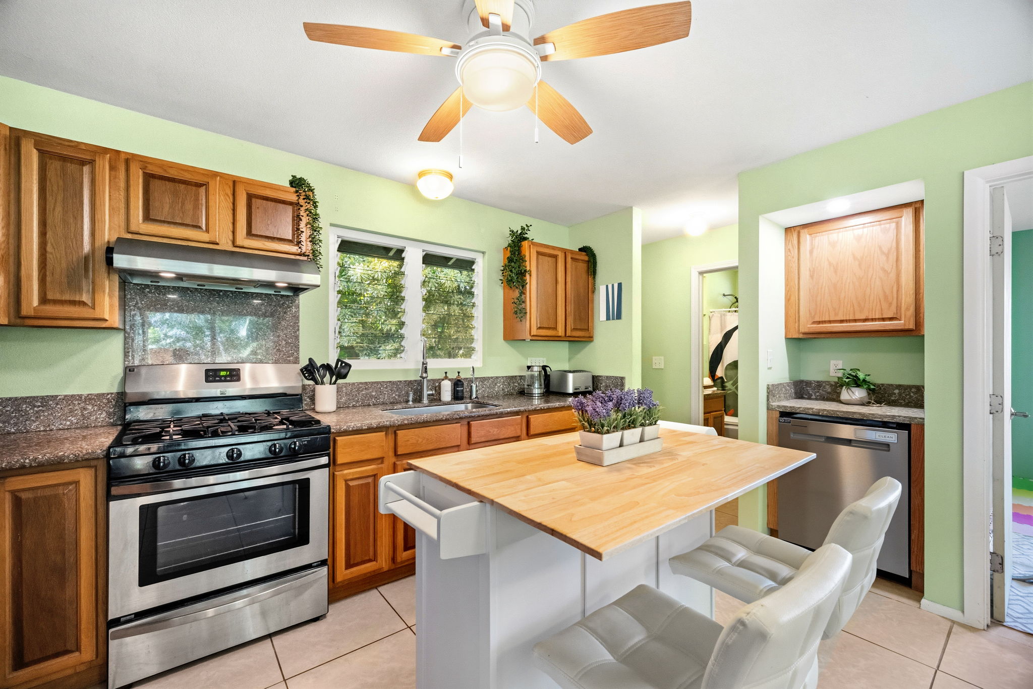 6250 Olohena Road, Unit 2 Kapaa, HI 96746 - Photo 2 of 29 a kitchen with a stove a sink dishwasher and a refrigerator with wooden floor