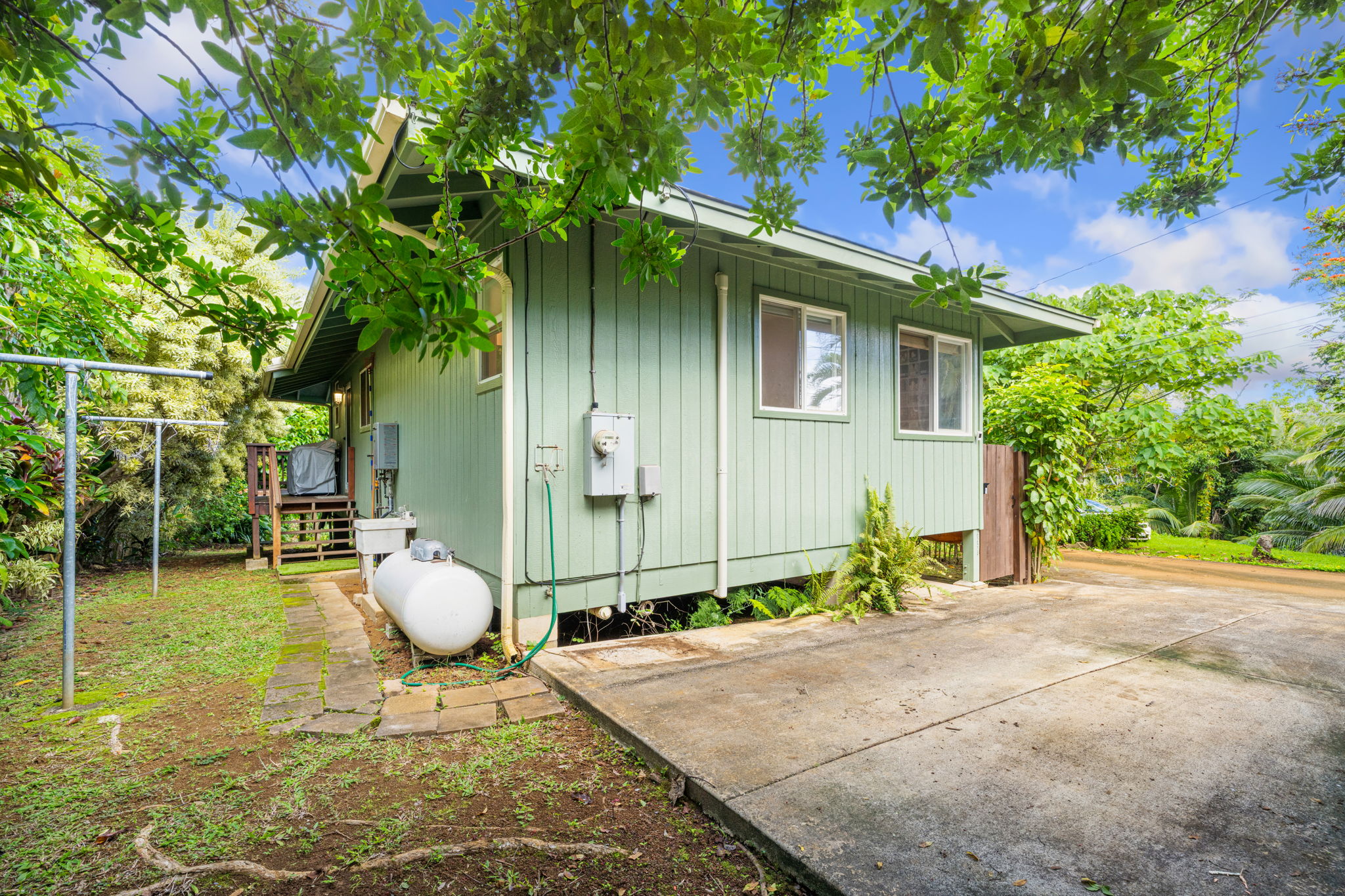 6250 Olohena Road, Unit 2 Kapaa, HI 96746 - Photo 21 of 29 a backyard of a house with table and chairs and potted plants
