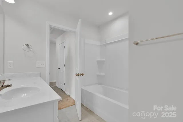 a bathroom with a double vanity sink mirror and chandelier
