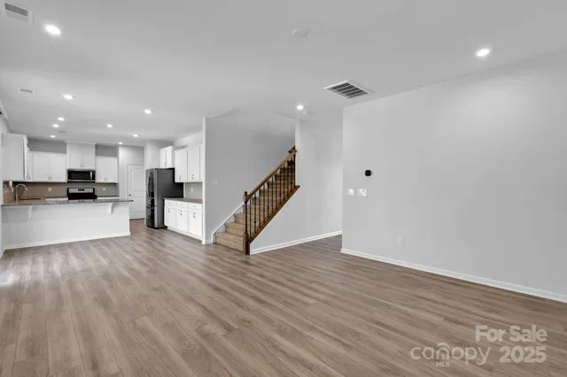 a view of a kitchen with wooden floor and stairs